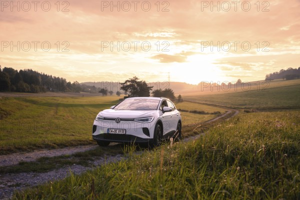 A car on a dirt road at sunset in a rural setting, VW ID4 electric car, Deer Carsharing, Calw, Germany