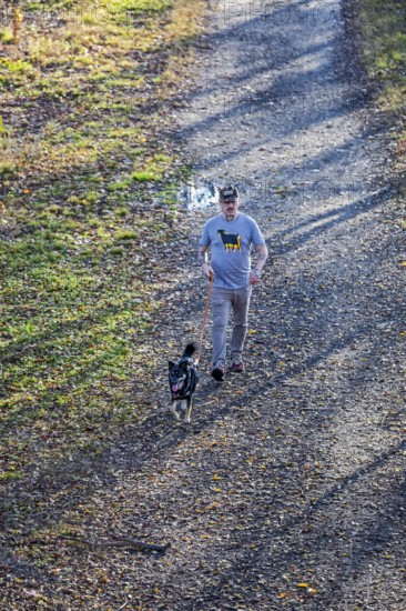 Washington, DC - A man walks his dog on the Kingman Island Trail. Kingman Island is in the Anacostia River