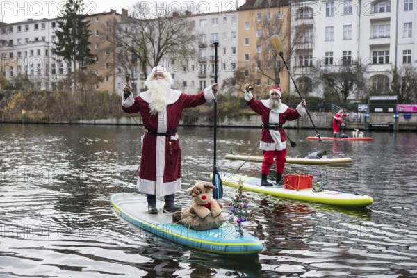 Water sports enthusiasts dressed up as Santa Claus ride SUPs on the Spree in Berlin on 30.11.2025