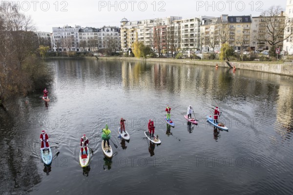 Water sports enthusiasts dressed up as Santa Claus ride SUPs on the Spree on the banks of the Federal Council in Berlin on 30.11.2025