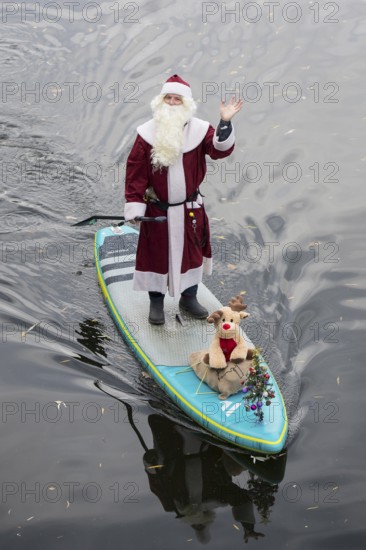 A water sports enthusiast dressed up as Santa Claus rides a SUP on the Spree in Berlin on 30.11.2025