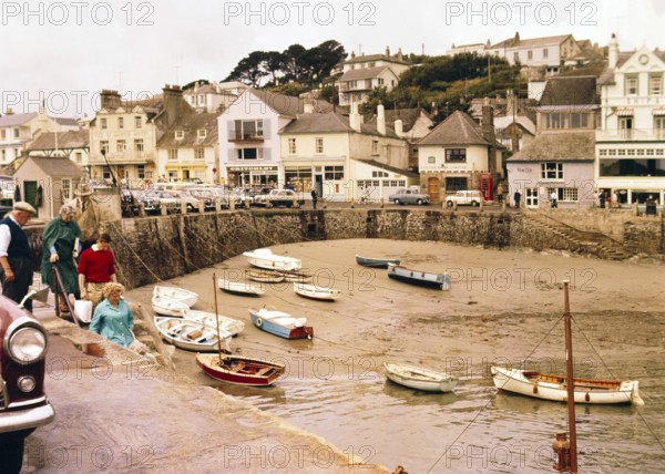 Historic waterfront buildings, boats at low tide in harbour at St Mawes, Cornwall, England, UK, c 1960