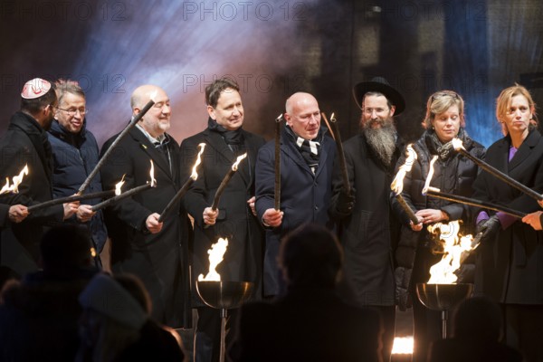 Karsten Dreinhöfer (Chairman of the Margot Friedländer Foundation) and Kai Wegner (Governing Mayor of Berlin) light the fire together with other participants at the lighting ceremony to mark 20 years of Hanukkah in front of the Brandenburg Tor, Berlin, 17 December 2025