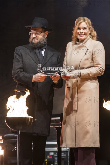 Julia Klöckner (President of the German Bundestag) receives a gift from Yehuda Teichtal (Rabbi of the Chabad-Lubavitch movement) at the lighting of lights to mark 20 years of Hanukkah in front of the Brandenburg Tor, Berlin, 17 December 2025