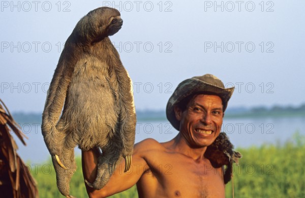 A man who runs a small private zoo near Iquitos on the Amazon shows a sloth, Peru, South America, September 1997, vintage, retro, old, historic