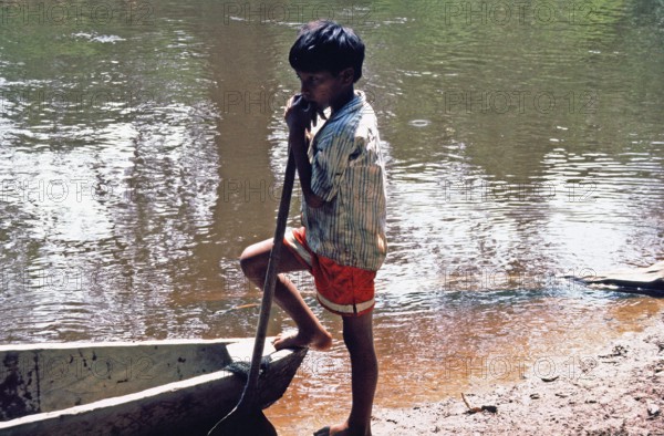 Little boy standing next to a boat, Rio Yanayacu, Amazon region near Iquitos, Peru, South America, September 1997, vintage, retro, old, historic
