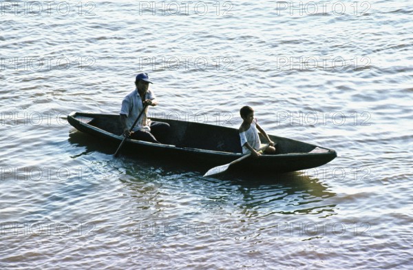 Father and child in a paddle boat on the Amazon near Iquitos, Peru, South America, September 1997, vintage, retro, old, historic