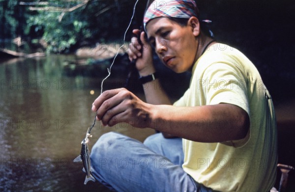 Man caught fish to be used as bait for piranhas, Rio Yanayacu, Amazon region near Iquitos, Peru, South America, September 1997, vintage, retro, old, historic