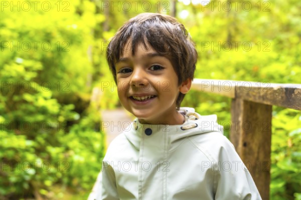 Young child smiles while exploring a lush rainforest trail in ucluelet, a town on vancouver island, british columbia, canada, enjoying the beauty of nature and the tranquility of the outdoors
