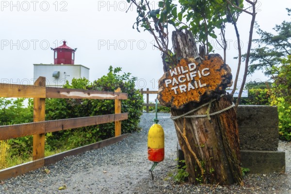 Wild pacific trail sign marking the hiking path near amphitrite point lighthouse in ucluelet, british columbia, offering stunning views of the pacific ocean and nature