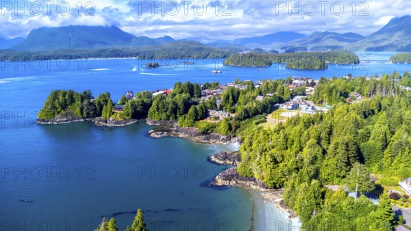 Breathtaking aerial view of tofino, a charming town on vancouver island, capturing its stunning coastline, lush forests, and vibrant blue waters of clayoquot sound on a summer day