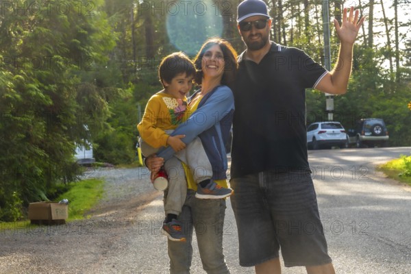 Happy family waving, enjoying their summer vacation in tofino, a popular tourist destination on vancouver island, british columbia, known for its beautiful beaches and lush rainforests