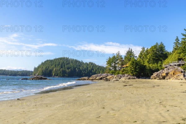 Golden sands meet crystal clear waters under a vibrant blue sky, creating a serene paradise at mackenzie beach, near tofino, on vancouver island, british columbia