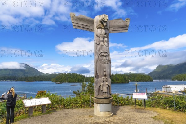 Wooden totem pole overlooking the ocean inlet in tofino, a small district on vancouver island in british columbia, canada, representing first nations culture and history