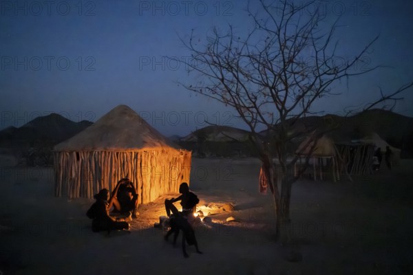 Himba at the campfire in the evening, night view, Himba huts, traditional Himba village in the savanna, Kaokoveld, Kunene, Namibia