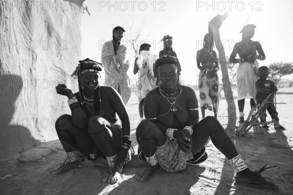 Black and white, woman and children in the village, Hakaona people, also Havakona or Hakawona, near Opuwo, Kunene, Namibia