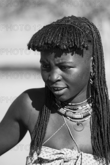 Black and white, portrait, brightly decorated woman of the Hakaona tribe, also Havakona or Hakawona, near Opuwo, Kunene, Namibia