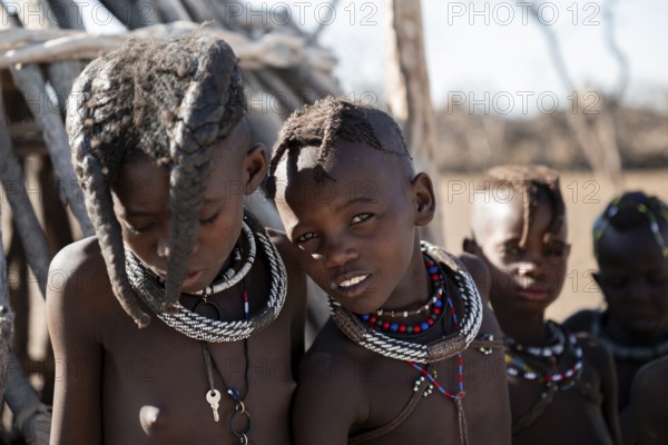 Himba children standing at hut, traditional Himba village, Kaokoveld, Kunene, Namibia