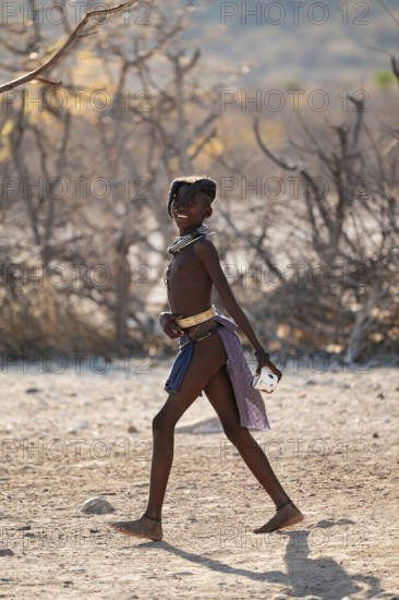 Himba child running in the village, traditional Himba village, Kaokoveld, Kunene, Namibia