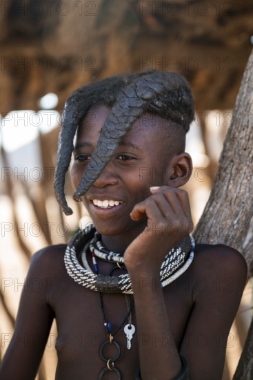 Portrait, Himba girl leaning against hut, traditional Himba village, Kaokoveld, Kunene, Namibia