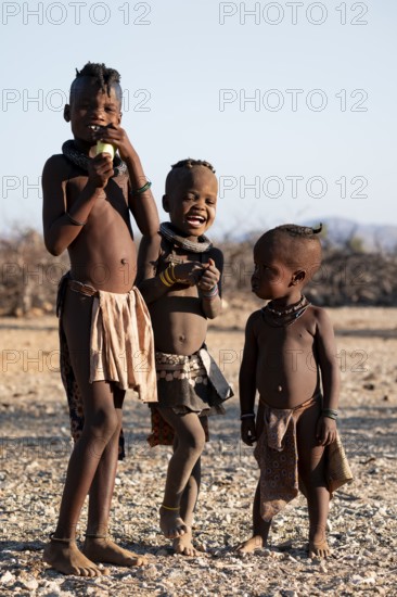 Three Himba children, traditional Himba village, Kaokoveld, Kunene, Namibia