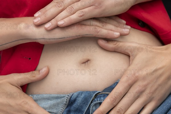 Symbolic picture of pregnancy, hands lying on a woman's stomach