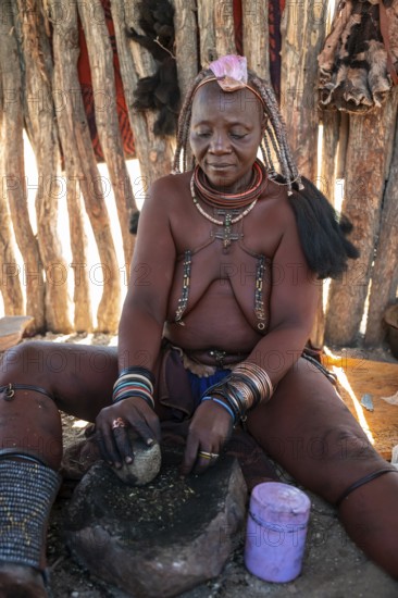 Himba woman milling grain, portrait, traditional Himba village, Kaokoveld, Kunene, Namibia