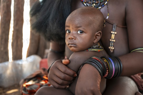 Himba woman with baby, traditional Himba village, Kaokoveld, Kunene, Namibia