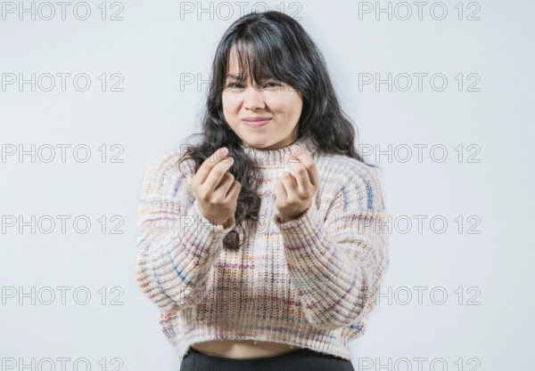 Cunning woman rubbing fingers showing money gesture isolated. Asian girl rubbing fingers asking for cash