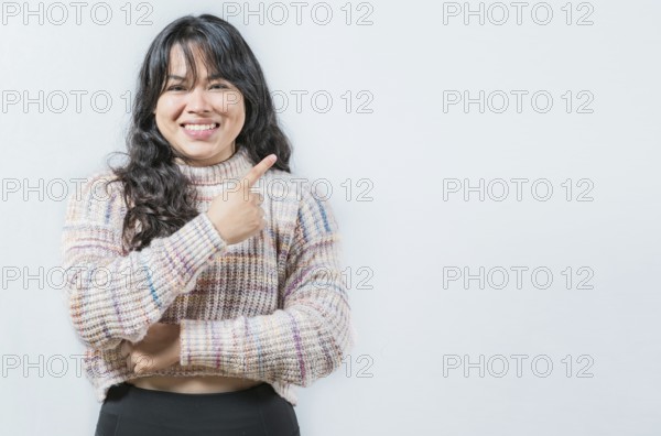 Beautiful asian woman pointing and presenting something, isolated. Cheerful asian girl pointing at a side isolated