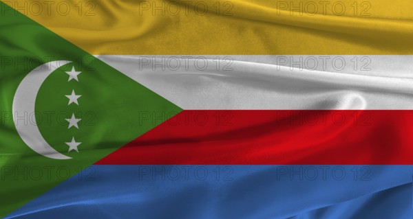 Flag of Comoros with fabric textured background. Close up of National flag of Comoros with realistic texture