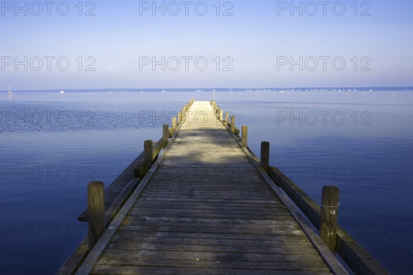 A long wooden walkway leads into the still water of a huge lake under a clear sky, Steinhude Steinhuder Meer