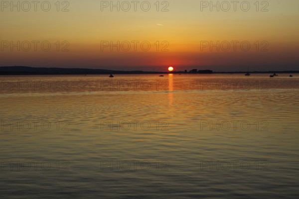 Sunset over a calm lake, orange sky, peaceful atmosphere, Steinhude Steinhuder Meer