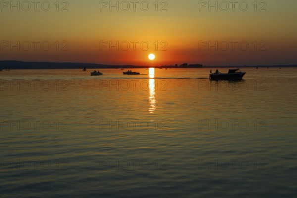 Sunset with several boats on Lake Steinhude, quiet evening mood, Steinhude