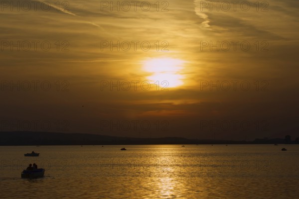 Several boats sail at atmospheric sunset on the lake, Steinhude, Steinhuder Meer