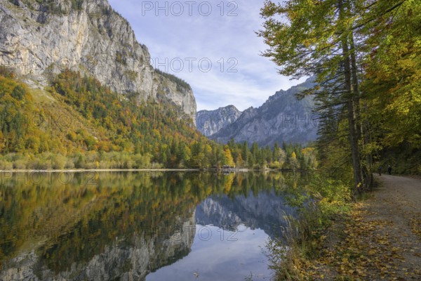 Rocks and autumn forest are reflected in the water of Lake Leopoldstein, Eisenerz, Styria, Austria
