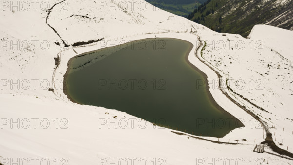 Another onset of winter in May, Riezler Alpsee, an artificially created lake, snow pond, feeds the snow cannons that completely snow the slopes of the Fellhorn and Kanzelwand cable cars, Allgäu Alps, Vorarlberg, Austria
