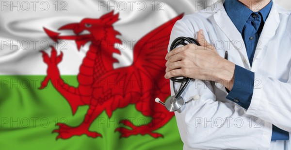 Wales National healthcare. Male doctor on Welsh flag. Doctor with crossed arms on Wales flag