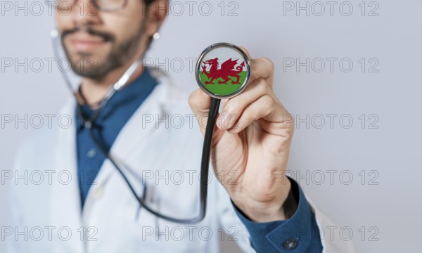 Doctor holding stethoscope with Wales flag. Wales health and care concept. Wales flag on stethoscope