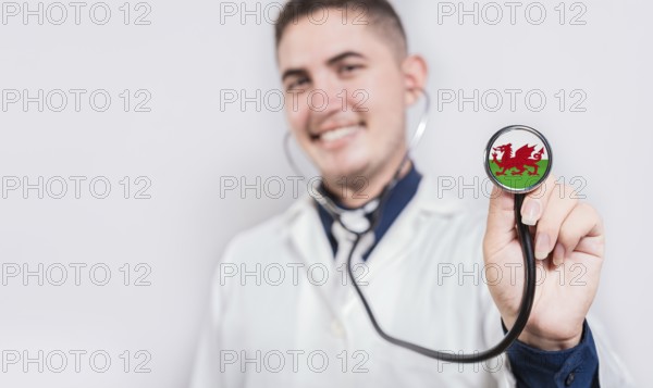 Doctor showing stethoscope with Wales flag. Wales national healthcare concept