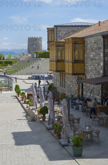 Outdoor terrace with decorated wooden areas and a view of a tower in the blue sky, Rabati Fortress, Akhaltsikhe, Samtskhe-Javakheti region, Samtskhe-Javakheti, Georgia