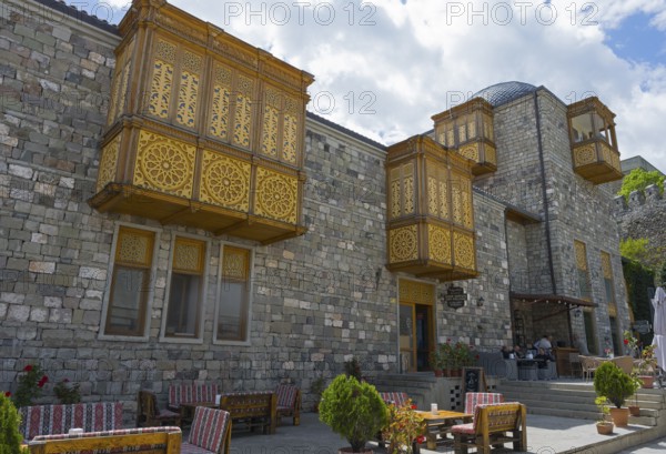 A building with decorative wooden windows, stone walls and cozy terrace furniture, Rabati Fortress, Akhaltsikhe, Samtskhe-Javakheti region, Samtskhe-Javakheti, Georgia