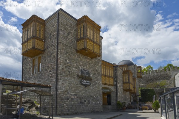 A historic building with intricately decorated wooden balconies against a cloudy sky, Rabati Fortress, Akhaltsikhe, Samtskhe-Javakheti region, Samtskhe-Javakheti, Georgia