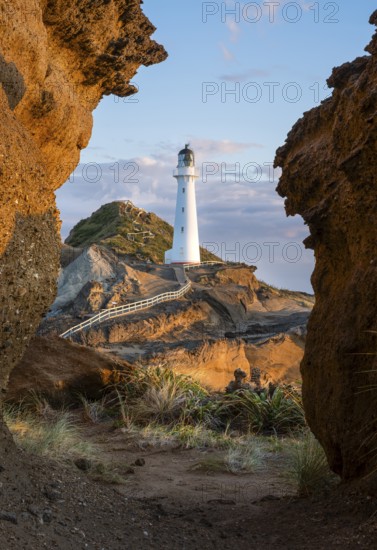 Castlepoint lighthouse on a rock, sea, sunrise. Castlepoint, Wairarapa Coast, Wellington Region, North Island, New Zealand