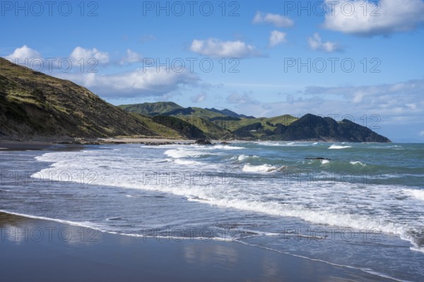 Castlepoint Beach, ocean, sandy beach, surf, mountains. Castlepoint, Wairarapa Coast, Wellington Region, North Island, New Zealand