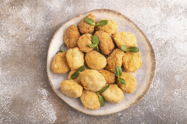 Fried crispy Chicken Nuggets with ketchup, microgreen on brown concrete background. top view, flat lay, close up