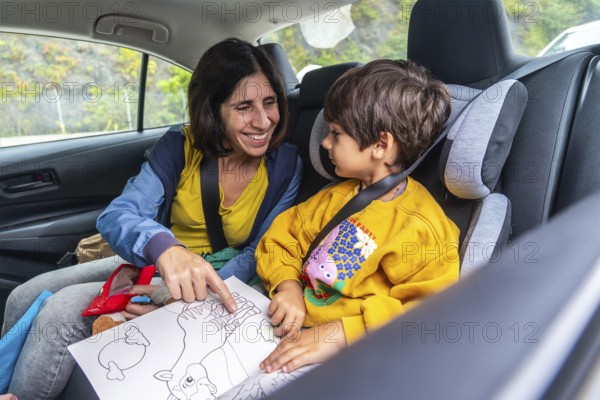 Mother and son sharing joyful moments during a road trip, reading a colorful children's book together and creating cherished memories that will last a lifetime