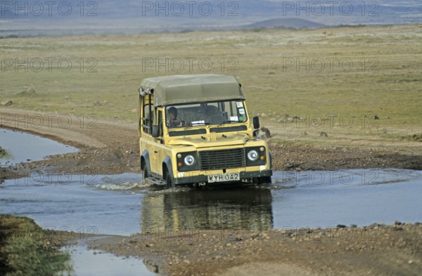 Safari vehicle driving through pools of water, Amboseli National Park, Kenya, Africa, June 2000, vintage, retro, old, historic