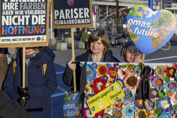 Grandmas for Future with crocheted flowers. They want to make a rug with 20, 000 flowers, which MPs must then walk over. At a demo with Extinction Rebellion on reaping the first tipping point, the death of freshwater corals and the 10th anniversary of the Paris Agreement, Washington-Platz, Berlin, 12.12.2025