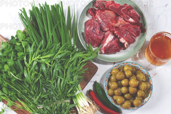 Ingredients for cooking chakapuli, canned tkemali, meat, herbs Georgian cuisine, top view
